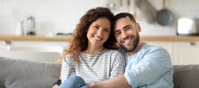 Man and woman sitting on couch smiling