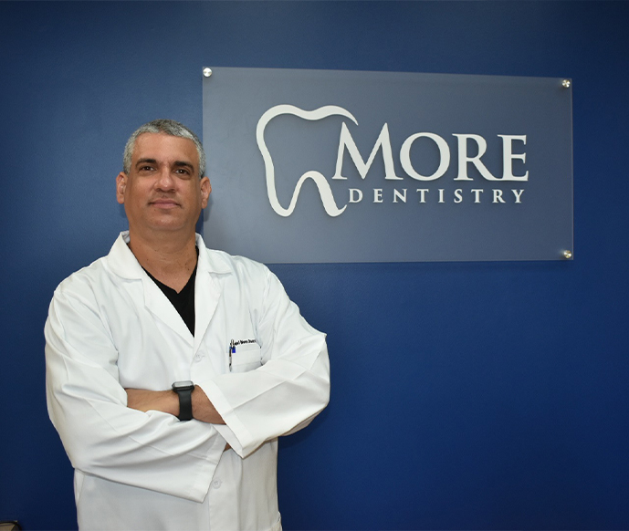 Older man leaning back in dental chair and smiling