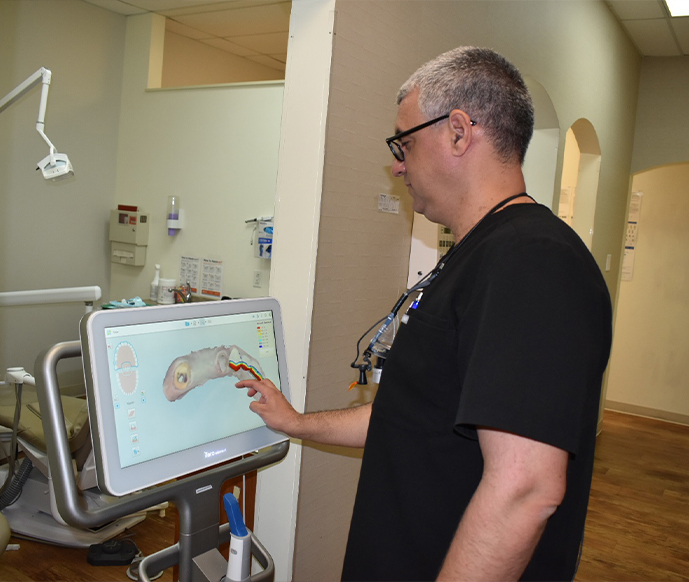 Woman smiling at dentist who has hand on her shoulder