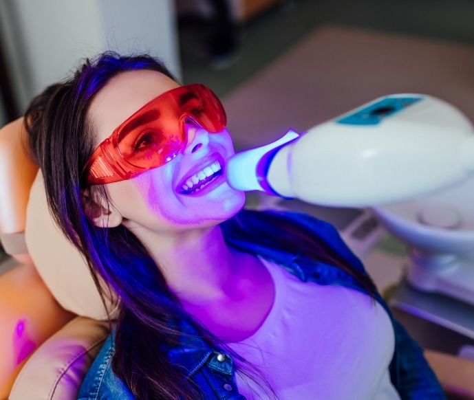 Female dental patient receiving teeth whitening