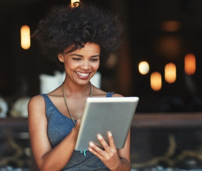 Woman smiling and looking at a tablet