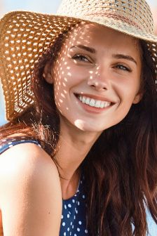 Woman with a floppy straw hat smiling