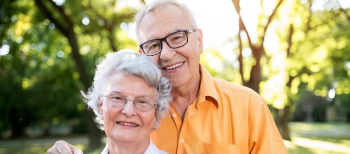 Senior couple standing outside and smiling