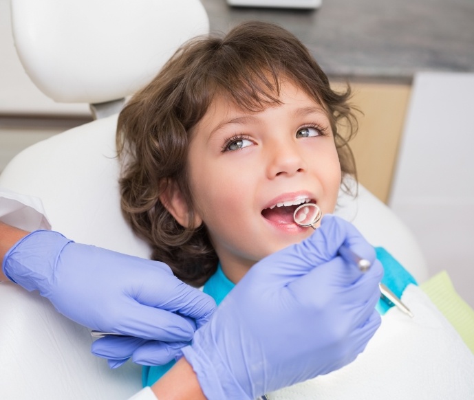 Child looking up while teeth are being examined by dentist