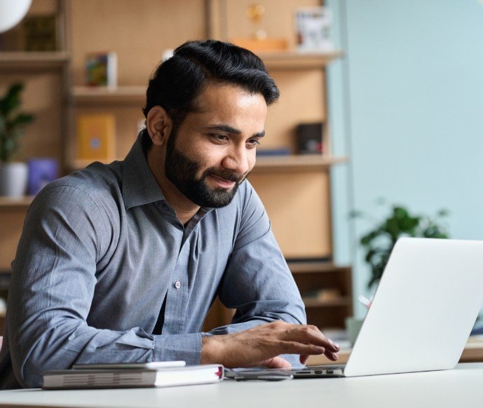 Bearded man looking at a laptop